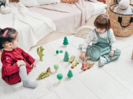 picture of kids sitting on the ground and playing with toys