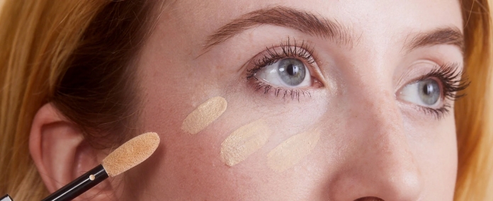 woman applying concealer makeup