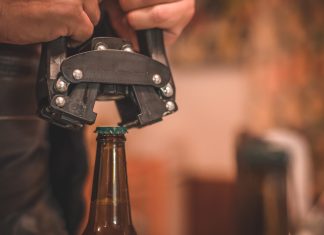 Close-up of beer bottle capping with capper machine.